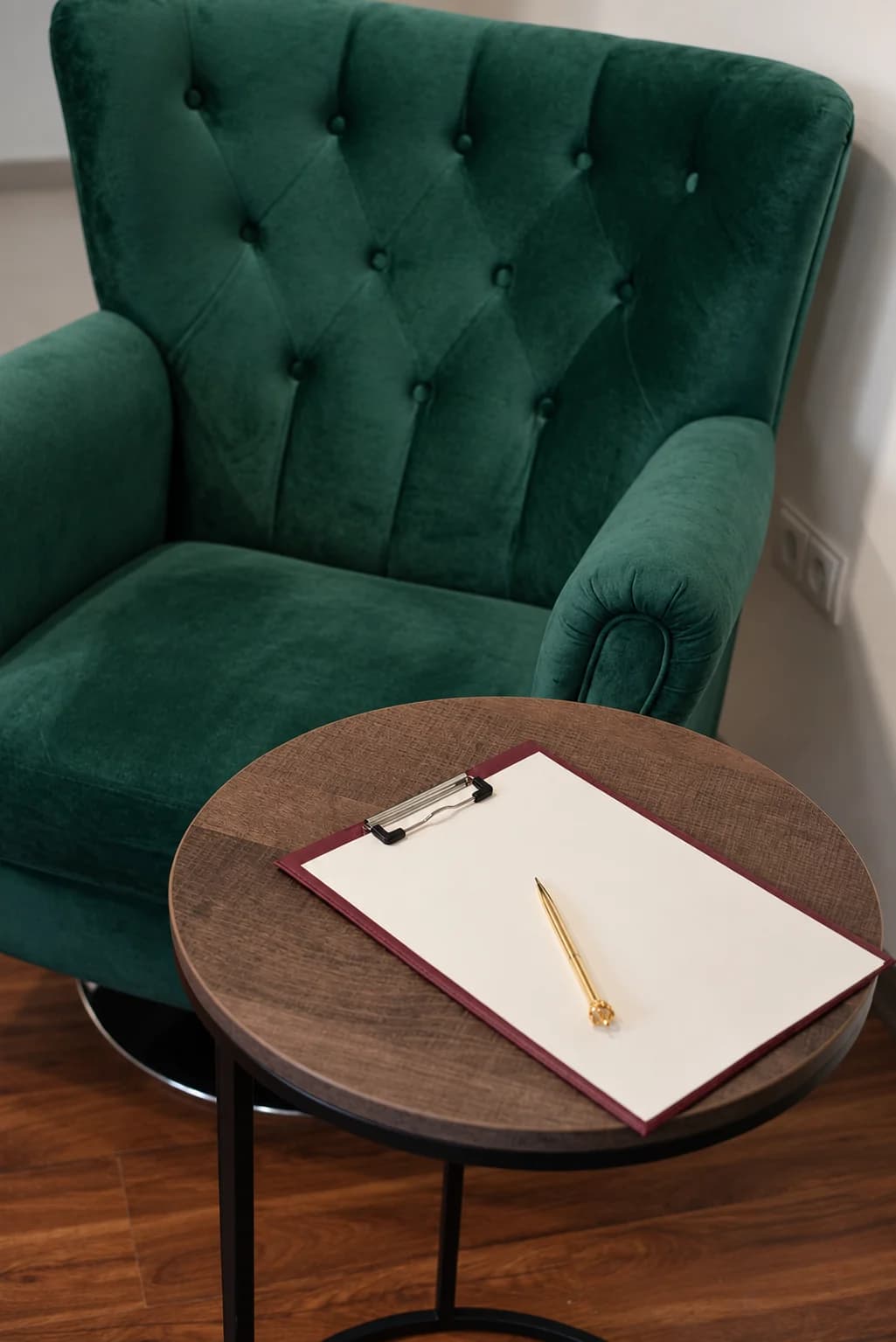 The real Yatros Med consulting room, empty: a green armchair, clipboard and pen on the table, with no people.